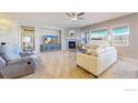 Bright living room featuring a fireplace, ceiling fan, and large windows for natural light at 11829 Deorio St, Parker, CO 80134