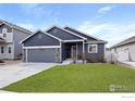 Charming home featuring a gray exterior, attached garage, and well-maintained front yard at 1525 Waterman St, Berthoud, CO 80513