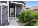 Inviting covered front porch with stone accents, beautiful plantings and easy access to a well-maintained lawn at 1525 Waterman St, Berthoud, CO 80513