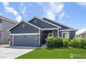 Single Gathering home featuring a well-manicured lawn, 2-car garage and beautiful stone accents at 1525 Waterman St, Berthoud, CO 80513
