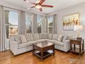 Bright and airy living room featuring a large sectional sofa, hardwood floors, and natural light at 2014 Pintail Dr, Longmont, CO 80504