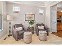 Comfortable seating area featuring two armchairs, ottomans, and natural light from the windows at 2014 Pintail Dr, Longmont, CO 80504