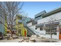 Exterior view of the condo complex featuring colorful facades, modern design, and a courtyard gathering area at 2018 Ionosphere St # 3, Longmont, CO 80504