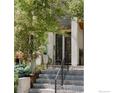 Inviting front entrance with modern design elements, concrete steps with iron railing, and mature landscaping enhancing curb appeal at 2125 Eliot St, Denver, CO 80211