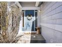 Inviting front entrance with a blue door, decorative wreath, and stylish accents, creating a warm welcome at 2201 Watersong Cir, Longmont, CO 80504