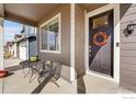 Charming front porch featuring outdoor seating, a front door with wreath, and views at 2425 Mountain Sky Dr, Fort Lupton, CO 80621