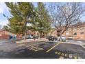 View of parking lot with reserved spots and surrounding multi-Gathering complex, interspersed with mature trees and a fire hydrant at 316 Wright St # 203, Lakewood, CO 80228