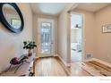 Bright foyer with hardwood floors, decorated table, and a view into a bedroom with plush carpet at 3325 Yale Dr, Broomfield, CO 80023