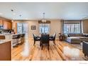 Open-concept living space with hardwood floors connecting the kitchen, dining, and living areas at 3325 Yale Dr, Broomfield, CO 80023