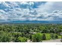 Expansive aerial view of a neighborhood with lush greenery, mountain views, and scattered residences at 4705 Chatham St, Boulder, CO 80301