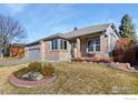 Charming single-Gathering home with brick facade, manicured lawn, covered porch, and attached two-car garage at 735 Orchard Ct, Louisville, CO 80027