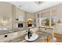 Open-concept living room with granite counters, fireplace, and large windows offering natural light at 735 Orchard Ct, Louisville, CO 80027