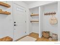 Bright entryway with floating shelves, coat rack, and a decorative basket, creating a welcoming first impression at 7599 Concord Dr, Boulder, CO 80301