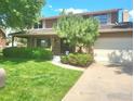 Inviting two-story home with a lush front lawn, mature tree, and attached garage at 7624 S Race St, Centennial, CO 80122