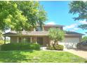 Traditional two-story home with well-maintained lawn, mature trees, and charming curb appeal at 7624 S Race St, Centennial, CO 80122