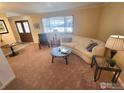 Comfortable living room with a curved sofa, neutral tones, and a view of the entryway at 7624 S Race St, Centennial, CO 80122