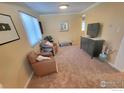 Cozy living room featuring comfortable armchairs, neutral carpet, and a modern entertainment center at 7624 S Race St, Centennial, CO 80122