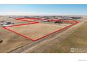 Wide aerial shot of a property with outlined boundaries, showing the home, large metal building, and vast land at 1050 S Manila Rd, Bennett, CO 80102