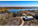 Expansive property featuring a house, separate building, and waterfront access with mature trees at 10752 County Road 7, Longmont, CO 80504