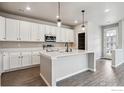 Bright kitchen with white cabinets, an island with quartz countertops, and stainless steel appliances at 2267 Peregrine Dr, Brighton, CO 80601