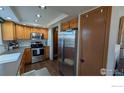 Updated kitchen featuring stainless appliances, wooden cabinetry, and efficient layout at 231 E 4Th Ave, Longmont, CO 80504