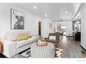 Bright living room featuring a modern design, a cowhide rug, stylish furniture, and a seamless flow into dining area at 450 S Decatur St, Denver, CO 80219