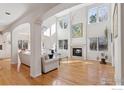 Bright, open living room with soaring ceilings, large windows, fireplace, and gleaming hardwood floors at 5338 Pine Valley Ct, Boulder, CO 80301