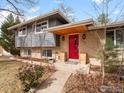 Inviting entryway with a bright red door, wood accents, and attractive landscaping at 5355 Kewanee Dr, Boulder, CO 80303