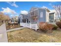 Beautifully landscaped home with a white picket fence, complemented by mature trees at 640 Gooseberry Dr # 607, Longmont, CO 80503