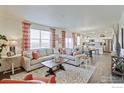Spacious living room showcasing a comfortable sectional sofa, bright windows, and seamless access to the open kitchen at 6513 14Th St, Frederick, CO 80530