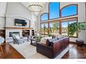 Bright living room featuring a fireplace, soaring windows, and comfortable seating area at 8733 Portico Ln, Longmont, CO 80503