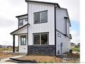 Modern two-story home showcasing its white facade, dark trim, and stone accents at 1047 Spartan Ave, Berthoud, CO 80513