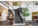 Elegant entryway featuring a curved staircase with black and white accents and hardwood floors at 12023 Coal Creek Heights Dr, Golden, CO 80403