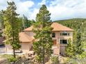 Multi-story home featuring a wooden deck and lush surrounding trees at 12023 Coal Creek Heights Dr, Golden, CO 80403