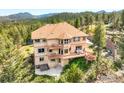 Beautiful three-story home with multiple balconies overlooking a treed lot, hot tub, and mountains at 12023 Coal Creek Heights Dr, Golden, CO 80403