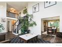 Open-concept living area features high ceilings, a dramatic staircase and a seamless transition to the dining space at 12023 Coal Creek Heights Dr, Golden, CO 80403