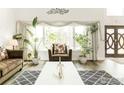 Bright living room featuring a large window with decorative curtains, plants, and a comfortable seating area at 12023 Coal Creek Heights Dr, Golden, CO 80403