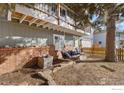 Cozy backyard with porch swing, brick accents and mature trees creating a serene outdoor living space at 1402 Athene Dr, Lafayette, CO 80026