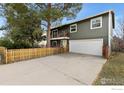 Charming two-story home with a spacious driveway and attached two-car garage, complemented by mature trees at 1402 Athene Dr, Lafayette, CO 80026