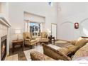 Inviting living room featuring high ceilings, a fireplace, and large window at 16478 Marion St, Thornton, CO 80602