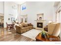 Bright living room boasting high ceilings, a cozy fireplace, and wood-style floors at 16478 Marion St, Thornton, CO 80602