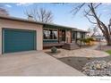 Inviting home exterior featuring a blue garage door and landscaping, creating a warm and welcoming atmosphere at 1700 Jewel Dr, Longmont, CO 80501