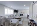 Bright living room featuring a comfortable gray sectional sofa and stylish tiled fireplace at 2136 S Balsam Ct, Lakewood, CO 80227