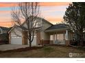 Charming two-story home with a well-manicured front yard and a two-car garage at 2215 Barn Swallow Dr, Longmont, CO 80504