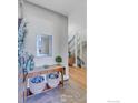 Foyer area with a wooden accent table, mirror, and view of the staircase at 2890 Curtis St, Denver, CO 80205