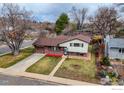 Aerial view of a red brick and vinyl home with an attached garage, driveway, and a well-maintained lawn at 3690 Conifer Ct, Boulder, CO 80304