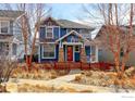 Charming two-story blue home with a red picket fence and nicely landscaped front yard at 5068 Uinta St, Denver, CO 80238