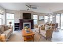 Comfortable living room featuring a fireplace, neutral furniture, and ample natural light at 5068 Uinta St, Denver, CO 80238