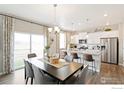 Eat-in kitchen area with barstool seating, stainless appliances, and modern lighting at 6543 13Th St, Frederick, CO 80530