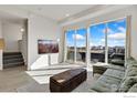 Bright living room featuring a large window with neighborhood views, modern decor, and access to the balcony at 737 Kubat Ln # B, Longmont, CO 80503